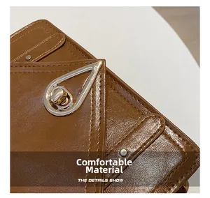 Detail of brown litchi pattern leather with a silver teardrop-shaped twist lock closure