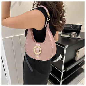 Detailed close-up of pink hobo bag featuring lychee grain leather and golden metal hardware