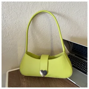 Detail of lime green leather baguette bag with a silver heart-shaped metal buckle