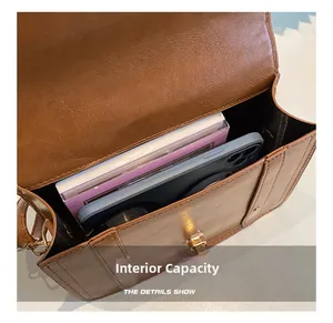 Close-up of retro brown PU leather shoulder bag interior showing internal capacity and lock