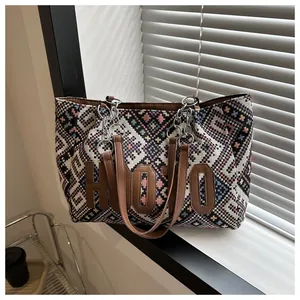Close-up of ethnic tote bag fabric texture with leather patch and metal chain strap