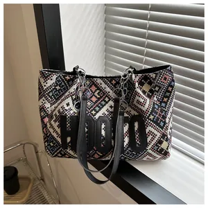 Close-up of geometric ethnic pattern fabric tote with leather handles and HOOTO logo