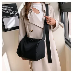 Close-up of black Oxford cloth tote bag with adjustable wide strap and dual zippers