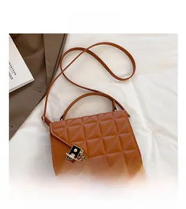 Détail d'un sac à main marron matelassé en similicuir avec motifs et fermoir en métal