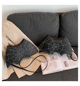 Detailed macro view of black bat-shaped crossbody bag with white spiderweb stitching texture