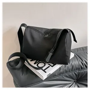 Macro view of minimalist black oxford fabric crossbody bag showing smooth zipper texture