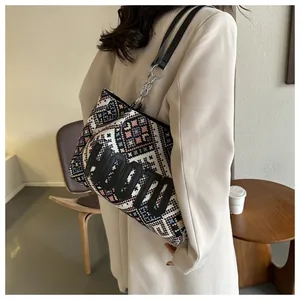 Detail of ethnic geometric tote bag featuring black HOOTO embroidery and metal chain strap