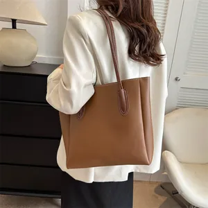 Large brown leather tote bag with white contrast stitching for daily casual or office use