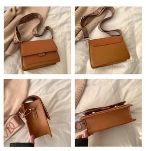 Detail view of brown color-block crossbody bag with wide jacquard shoulder strap