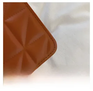 Vue détaillée de la texture du cuir caramel et des finitions des coutures matelassées