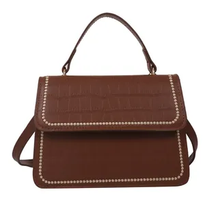 Vintage brown crocodile textured shoulder bag with floral stitching and adjustable strap