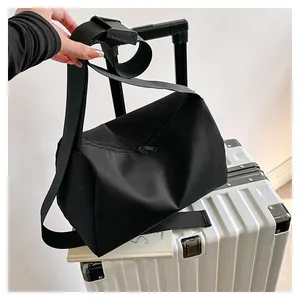 Detailed view of black nylon tote bag attached to a suitcase handle for easy travel