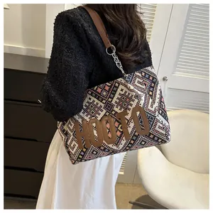 Detail of bohemian tote bag with geometric woven texture and HOOTO leather patch