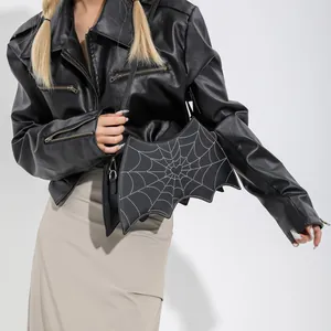 Gothic bat wing crossbody bag with spider web embroidery and heart detail on model