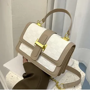 Close-up of contrast woven square texture with golden rectangular buckle on small flap bag