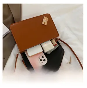 Intérieur du sac marron montrant l'espace pour téléphone, mouchoirs et rouge à lèvres