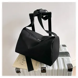 Close-up of black oxford cloth tote bag mounted on silver luggage handle for easy travel