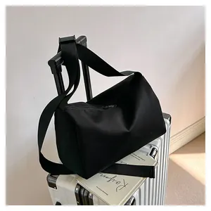 Black Oxford tote bag shown on a silver suitcase, ideal for travel and daily commuting