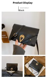 Detail of black crossbody bag with a gold heart-shaped metal twist lock and leather texture