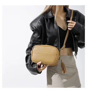 Close-up of yellow PU leather crossbody bag with tassel and metal chain strap