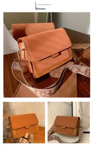 Detail of a brown textured crossbody bag with a wide jacquard patterned shoulder strap