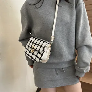 Classic black and white tweed crossbody bag with golden lock and white leather strap