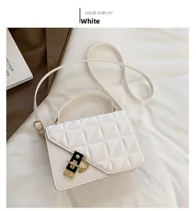 Détail d'un sac à bandoulière matelassé blanc avec ferrures dorées et boucle noir et or