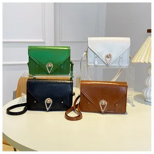 Detailed shot of four vintage crossbody bags in green, white, black and dark brown shades