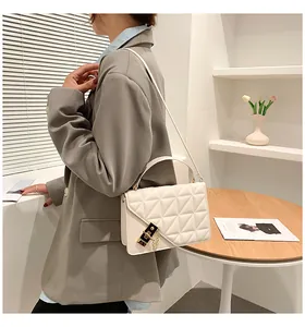 Détail d'un sac à bandoulière matelassé beige avec fermoir doré et chaîne élégante