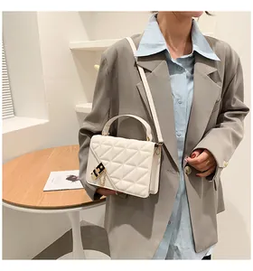 Détail du sac bandoulière matelassé blanc crème avec boucle dorée et chaîne
