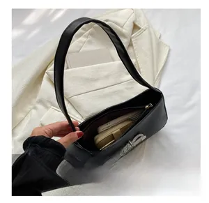 Internal capacity of black shoulder bag with bow showing phone and wallet