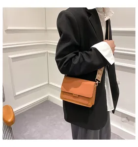 Detailed view of caramel leather crossbody bag with jacquard pattern wide strap on model