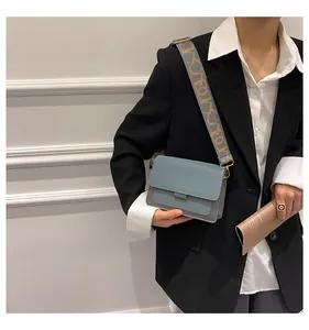 Detail of gray-blue rectangular crossbody bag with patterned jacquard wide shoulder strap