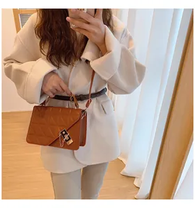 Gros plan du sac bandoulière en cuir matelassé marron avec chaîne et rabat asymétrique
