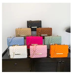 Close-up of V-shaped quilted crossbody bags in multiple colors with golden chain straps