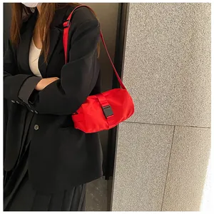 Detailweergave van de rode oxford stoffen crossbody tas met zwarte gesp gedragen door model