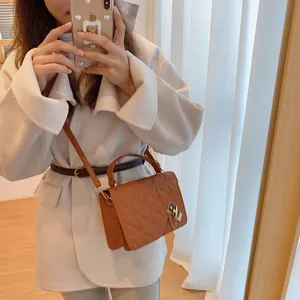 Sac bandoulière matelassé marron caramel élégant avec chaîne dorée porté par un mannequin
