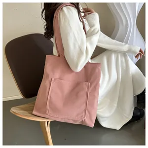 Détail du sac cabas en velours côtelé rose montrant la texture douce et la poche