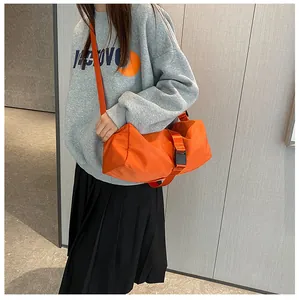 Detail van helder oranje oxford crossbodytas met verstelbare riem en sportief ontwerp