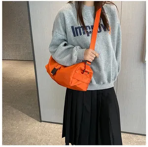 Detailopname van feloranje Oxford stoffen cilindertas met zwarte gespdetails