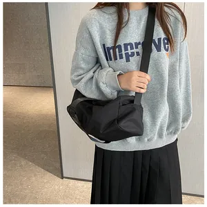 Detail van de zwarte Oxford stoffen crossbodytas met een zachte, geplooide toast-vorm