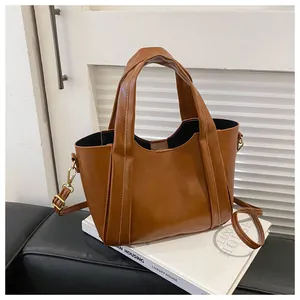 Detail view of caramel brown faux leather tote bag with sturdy handles and shoulder strap