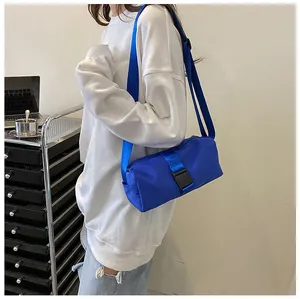 Levendige blauwe nylon crossbodytas vanaf de zijkant gezien op een model voor woon-werkverkeer