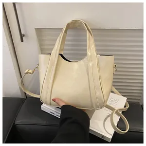 Detail view of cream-white bucket bag with premium glossy PU leather and decorative stitching