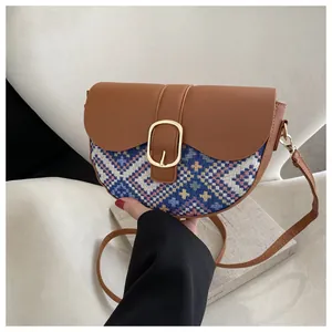 Detail of ethnic style saddle bag with geometric weaving and gold oval buckle