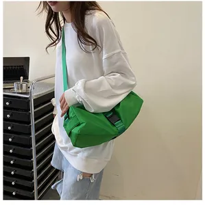 Detail van een groene oxford crossbodytas met verstelbare zwarte gesp en brede riem