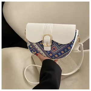 Detail of bohemian saddle bag featuring patchwork woven fabric and gold metal buckle