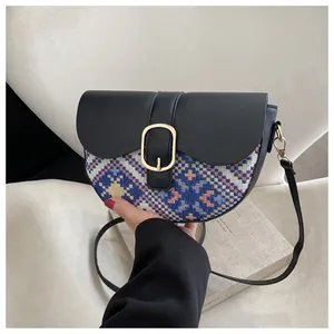 Close-up of ethnic saddle bag with blue geometric pattern and gold oval metal buckle