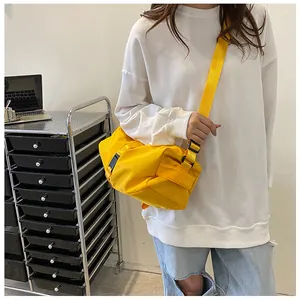 Detail van een felgele Oxford crossbodytas met verstelbare riem gedragen door model
