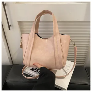 Close-up of light pink PU leather bucket bag with gold hardware and fine stitching detail